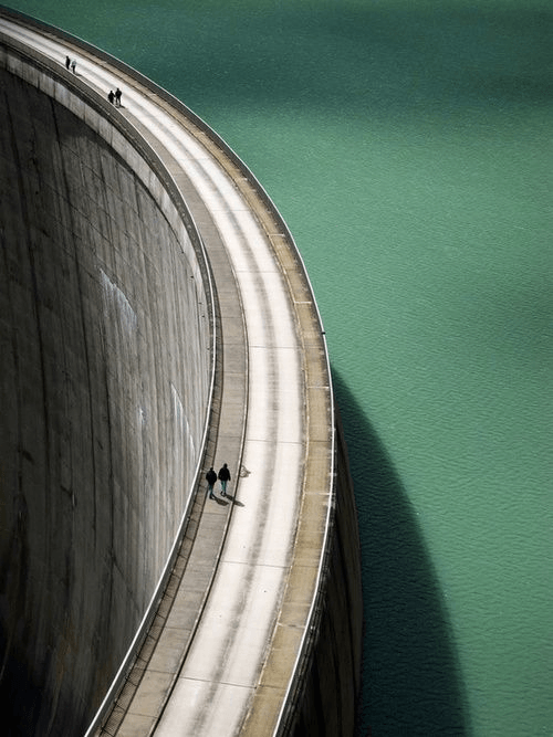 Curved concrete wall against a teal sky